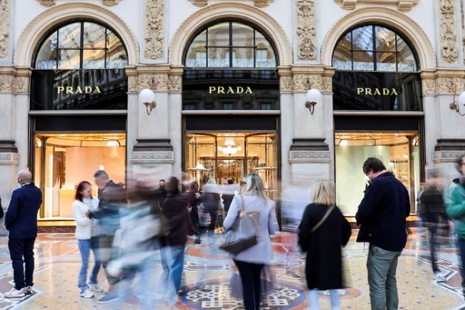 People walk past a Prada store in Galleria Vittorio Emanuele II, in Milan, Italy, September 27, 2025. REUTERS/Yara Nardi/File Photo