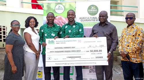 Nicholas  Afrifa (3rd from right), GIRSAL’s CEO, being assisted by Samuel Yeboah (3rd from left), Chief Operating Officer of GIRSAL, to present a dummy cheque to Eric Opoku (2nd from right), Food and Agriculture Minister. George Abradu-Otoo (right), CEO of NAFCO, and other management staff of GIRSAL 