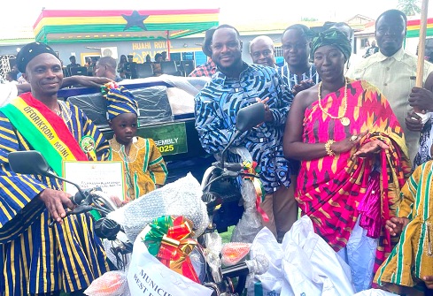 Oheneyere Hoahi Akosua Asamoah II (right in front), Queenmother of Boadi,  Anwel Sadat Ahmed (2nd from right), MCE  for Oforikrom, applauding after jointly handing over a tricycle to Alhassan Musa Kpabi (left), who emerged as the Best Farmer for the Oforikrom Municipality