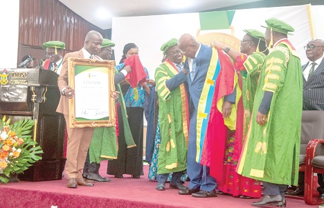 Hackman Owusu Agyemang, an alumnus and former Minister of State, being decorated by Akyeamfour Asafo Boakye Agyemang-Bonsu, Governing Council Chairman, KNUST, and Prof. Mrs Rita Akosua Dickson (2nd from right), the Vice Chancellor, KNUST, while the Asantehene, Otumfuo Osei Tutu II(right), cheerfully looks on