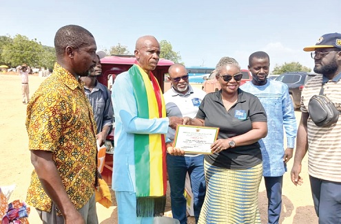 Agatha Quayson (3rd from right), Country Director of Hunger Project, presenting a certificate to Simon Tettey Nyaglortor, the overall best farmer