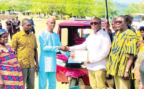 Thomas Ampem Nyarko (2nd from right), Member of Parliament for Asuogyaman, presenting a certificate to Simon Tettey Nyagblortor, the best farmer