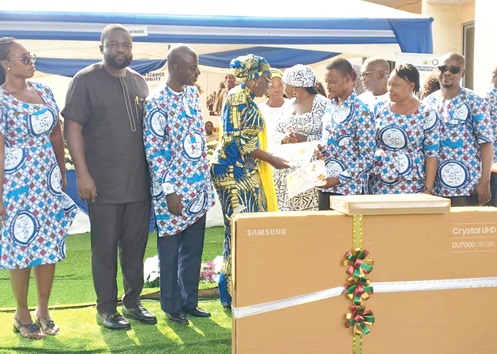 Hajia Katumi Atta Natogmah (4th from left), Greater Accra Regional Director of Education,  presenting the award of overall best teacher in the Krowor Municipality to Patrick Kartey Addonor, a teacher at the Nungua Presbyterian Junior High School. With them are Azeriya G. Ayeriga (3rd from left), Krowor Municipal Director of Education, Paul Afotey Quaye (2nd from left), MCE for Krowor Municipal Assembly, and other teachers