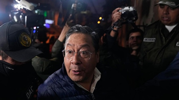 Police officers escort former President Luis Arce to San Pedro Prison after his arrest as part of a corruption investigation in La Paz, Bolivia, on December 12, 2025. | Photo Credit: AP