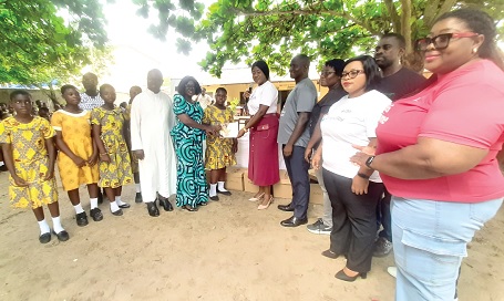 The Consolidated Bank Ghana team, led by Ami Korkor Adenu (arrowed), Regional Manager in Accra Central, presenting the books to Patience Addy (4th from left), Headmistress of St Mary’s R/C Basic School. With them is Very Rev. Father Edmund Donkor-Baine (3rd from left), Local Manager at St Mary’s R/C Girls Basic School.  Picture: ESTHER ADJORKOR ADJEI