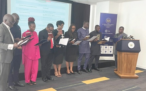 Samuel Nartey George (right), Minister of Communication, Digital Technology, and Innovations, swearing in the 11-member facilitator body in Accra