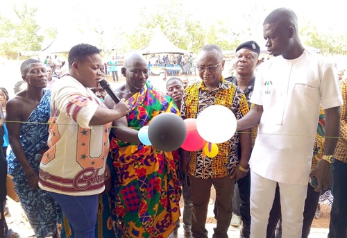 Nana Yaw Kumah Dwenewokroho (2nd from left), Chief of Korjee, being assisted by Peter Dongi (right), Banda District Chief Executive, and Simon Adams (2nd from right), District Director of Health, to cut the tape to inaugurate the Korjee CHPS compound