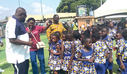 Diana Hamilton (with mic),  gospel musician, and Michael Nii Kpakpo Allotey (left), Mayor of Accra, dancing with some of the schoolchildren during the party