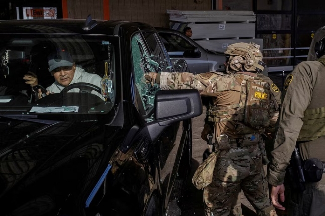 U.S. federal agents smash a car window while trying to detain a man during an immigration raid, after U.S. President Donald Trump ordered increased federal law enforcement presence to assist in crime prevention, in Chicago, Illinois, U.S., December 17, 2025. REUTERS/Jim Vondruska/File Photo