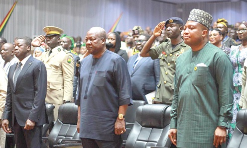 President John Dramani Mahama (middle); Faure Gnassingbe (left), President of the Council of Ministers of Togo, and Samuel Okudzeto Ablakwa (right) paying the appropriate compliment while the Ghana National anthem was being played