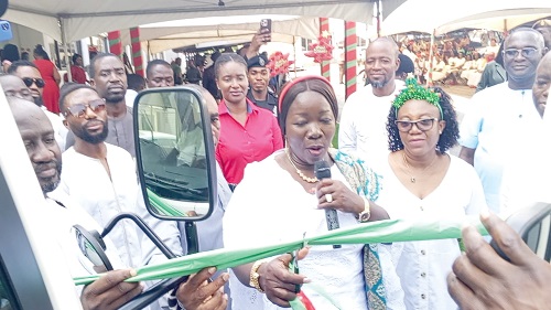 Elizabeth Ofosu-Adjare (middle), Minister of Trade, Agribusiness and Industry, cutting the sod to mark the commissioning of two new buses for staff of the ministry