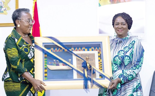 Professor Naana Jane Opoku-Agyemang (right), the Vice- President, receiving a citation from Emelia Arthur (left), the Minister of fisheries and Aquaculture, during her working visit to the ministry