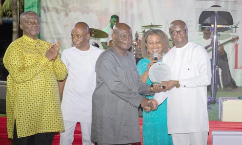 Mr D.O.K. Owusu (middle), the Chairman of the Board of Directors of ARB Apex Bank, being assisted by other directors, to present a citation to Alex Kwasi Awuah, the outgoing Managing Director of the bank