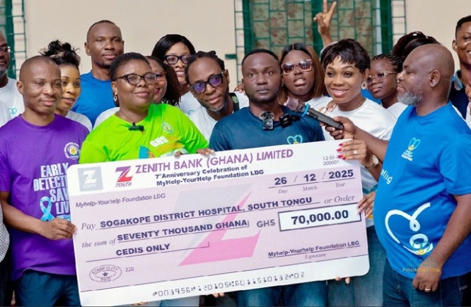 Mr Nicholas Cofie, President and Founder of MyHelp-YourHelp Foundation, presenting a dummy cheque covering GH¢70,000 to staff of the Sogakope District Hospital