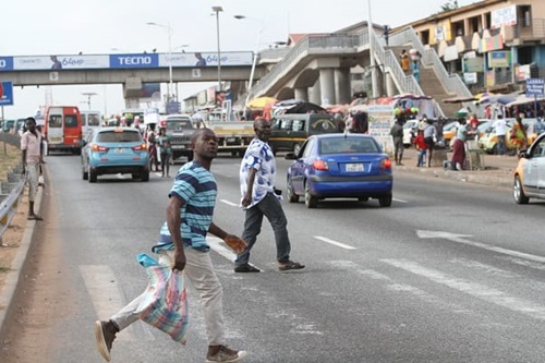 Some pedestrians risking their lives under a footbridge