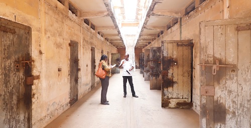 Mr Benjamin Afagbegee (right), Senior Conservator of Monuments explaining to Doreen Hammond, Editor of The Mirror, features of the prison architecture, during a tour of the facility