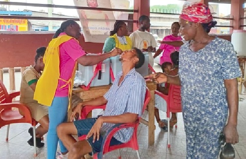 A health official administering the vaccine to a community member A health official administering the vaccine to a community member