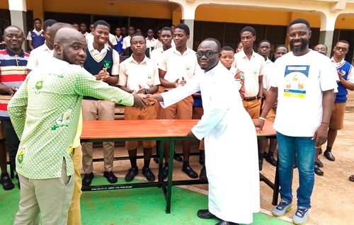 Moses Hinneh (left), a member of the Year Group, handing over the furniture to Rev. Fr Felix Taah (2nd from right), Rector of the school Moses Hinneh (left), a member of the Year Group, handing over the furniture to Rev. Fr Felix Taah (2nd from right), Rector of the school
