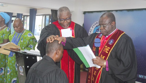 Rt Rev. Samuel Prosper Dzomeku (right), the Moderator of the Global Evangelical Church, and Dr Yohanes K. Ahiabu (left), the Synod Clerk of the church, laying hands on a newly ordained pastor Rt Rev. Samuel Prosper Dzomeku (right), the Moderator of the Global Evangelical Church, and Dr Yohanes K. Ahiabu (left), the Synod Clerk of the church, laying hands on a newly ordained pastor