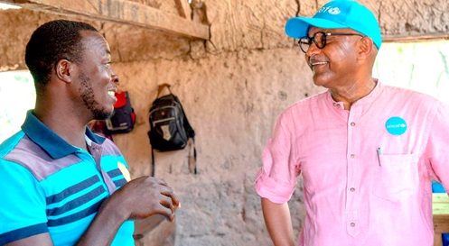 Osama Makkawi Khogali (right), UNICEF Representative, interacting with a teacher from Bumpata DA Basic School, Afram Plains