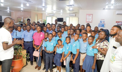 Timothy Ngnenbe (left), a Senior Reporter with the Daily Graphic, explaining to students of the New Generation Prep/ JHS at Ahafo-Nkaseim some of the stages in the newsroom during a visit to the Graphic Communications Group Ltd. Picture: EDNA SALVO KOTEY