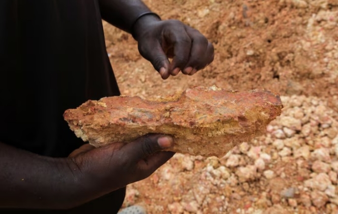 An illegal artisanal miner inspects an excavated rock for traces of gold at the Prestea-Huni Valley Municipal District in the Western Region, Ghana August 17, 2024. REUTERS/Francis Kokoroko Ghana has lost $11 billion to gold smuggling, links to UAE, report finds