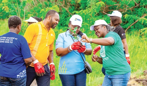 Sedinam Charity Afua Mammara (middle), Director, Human Resource, NPA, with Linda Ansah (right), the District Manager, Tema Ada Forest District, and Rasheed Duada (2nd from left), examining one of the seedlings during the tree planting exercise Sedinam Charity Afua Mammara (middle), Director, Human Resource, NPA, with Linda Ansah (right), the District Manager, Tema Ada Forest District, and Rasheed Duada (2nd from left), examining one of the seedlings during the tree planting exercise