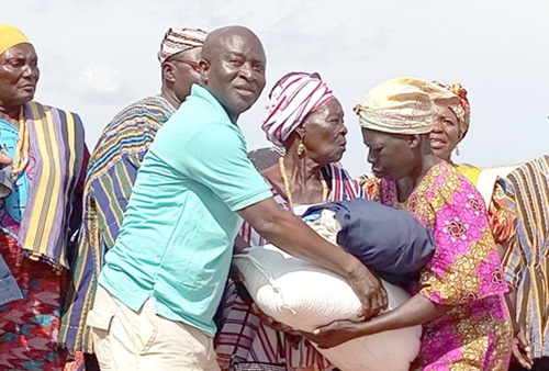 Nanleeb Konlan, Chief Executive Officer of the Yennutona Foundation, presenting some of the items to a beneficiary