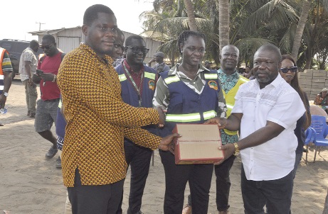   James Gunu (right), Volta Regional Minister, and Professor Nana Ama Brown Klutse (middle), EPA CEO, presenting some relief items to a member of the community