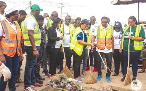 Linda Obenewaa Akweley Ocloo (3rd from right), Greater Accra Regional Minister, clearing filth from the gutters at Madina. With her  are some personalities that participated in the regional sanitation day