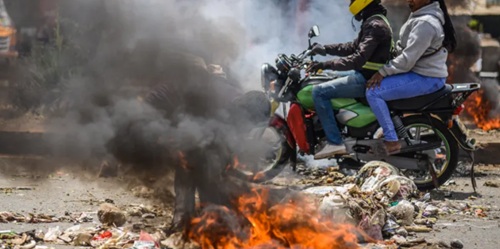 Nearby roads were blocked by piles of burning rubbish and littered with rocks Nearby roads were blocked by piles of burning rubbish and littered with rocks