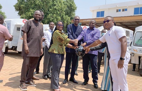 Abena Amedormey, Country Representative of CRS, presenting keys of the ambulances to the directors. INSET: Some of the tricycle ambulances