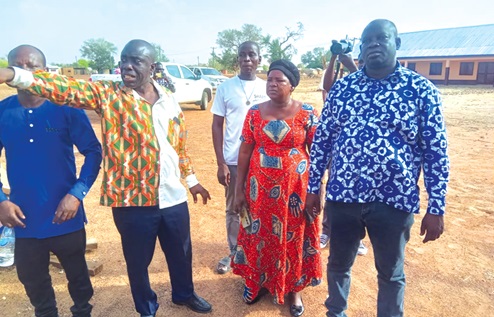 John Ankoh (hand stretched), the Bongo District Director of the GES, explaining a point to Charles Bawaduah (right), MP for Bongo, during a visit to Dua Yikine Basic School