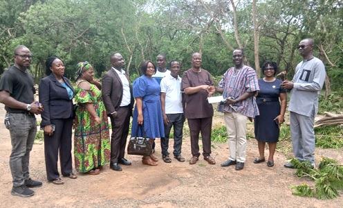  Professor Christopher Adjei (4th from right), Global Alumni President of the college, presenting a cheque for GH¢10,000 to Professor Samuel Atintono (3rd from right), Principal of the college