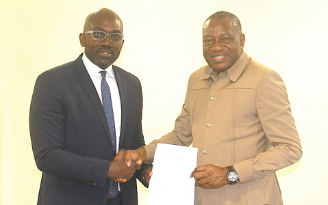 Opoku-Boahin (left) and Dr Pelpuo exchanging their respective signed documents