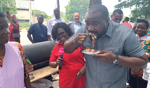 John Dumelo (right), Deputy Minister of Food and Agriculture, tasting  grilled chicken as Dr  Victoria Afua Norgbey (left), the President of WIP VAC, looks on. 