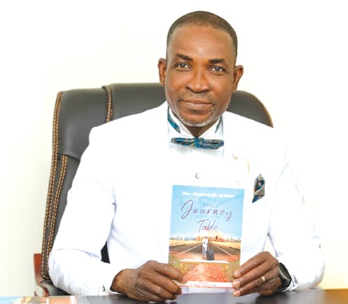 Rev. Stephen Wilfred Arthur,  Founder of Kingdom Family International Church,  with the copy of his latest book after the launch