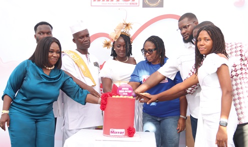 Grace Antwi Hayford (middle), The Mirror Model Mother, 2025, being assisted by Doreen Hammond (3rd from right), Editor, The Mirror; Regina Ofori (left), Head of Marketing and Brand, Ecobank Ghana PLC, and her family to cut the Mother’s Day cake. Picture: ELVIS NII NOI DOWUONA