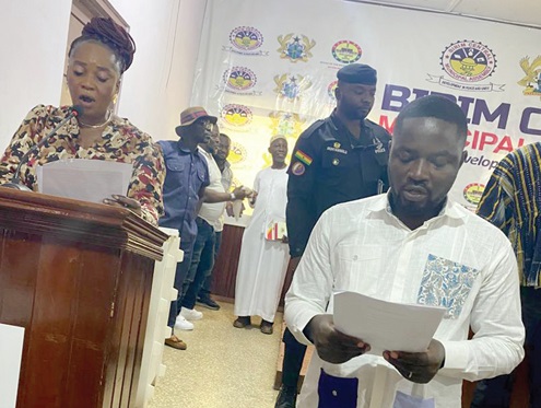 Rita Akosua Adjei Awatey (left), Eastern Regional Minister, swearing in Solomon Kusi-Brako (right) as MCE for Birim Central