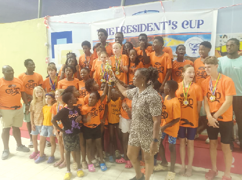 • Delphina Quaye, President of the Ghana Swimming Association, presnting the overall winners' trophy to the youngest members of Dolphins GH • Delphina Quaye, President of the Ghana Swimming Association, presnting the overall winners' trophy to the youngest members of Dolphins GH