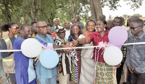 Jerry Ameko (3rd from left), Adaklu DCE, Togbe Dzegblade IV (in hat), Chief of Adaklu-Kodzobi, and other stakeholders jointly cutting the tape for the sod-cutting. INSET: The project site