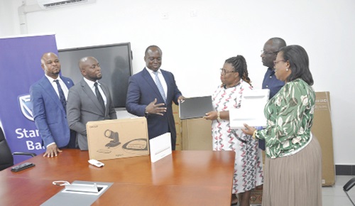 Harry Opoku Agyemang (middle), Head of Personal Banking, Stanbic Bank, presenting the items to Prof. Lydia Aziato while some officials of the bank and UHAS look on