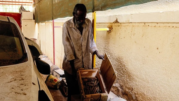 A Sudanese man shows a box of unexploded munitions found at a school in Khartoum, the country's capital