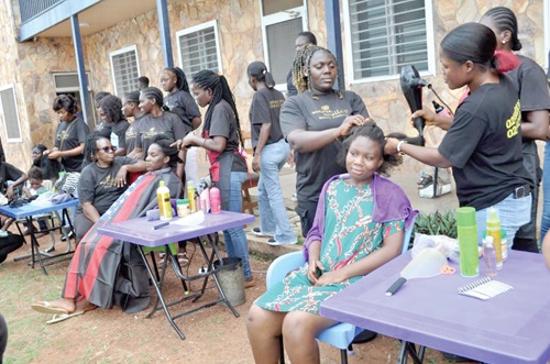 Staff of the Marie Noelle’s Beauty Academy braiding the hair of some of the inmates