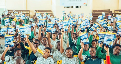 The students of Aburi Girls SHS raising the reusable sanitary pads they received The students of Aburi Girls SHS raising the reusable sanitary pads they received