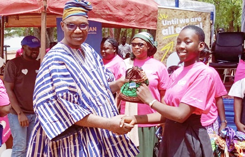 Constant Tchona, Country Director of Plan International Ghana, presenting sanitary pads to a student