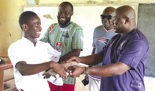 Mr Alexander Akwasi Acquah presenting a school uniform to one of the beneficiary pupils. Mr Alexander Akwasi Acquah presenting a school uniform to one of the beneficiary pupils.
