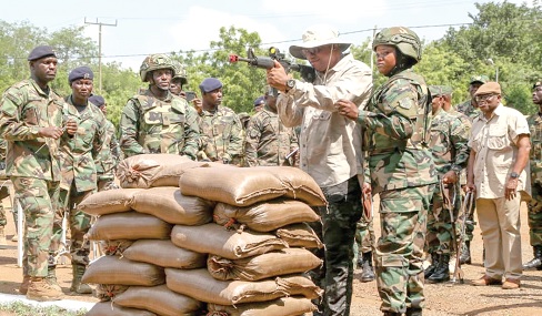 Ernest Brogya Genfi, Deputy Minister of Defence, taking aim with one of the weapons on display during the equipment exhibition
