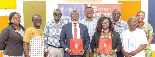 Dr Lucy Agyepong (2nd from right) and Prof. Samuel Boakye Dampare (3rd from left) displaying copies of the signed MoU. With them are officials of Academic City University and GAEC