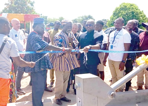 Charles Launga Pouzing (arrowed), Upper West Regional Minister, assisting Naa Domepeeh Gyereh, Vice-President of Nandom Traditional Council, to commission the water project